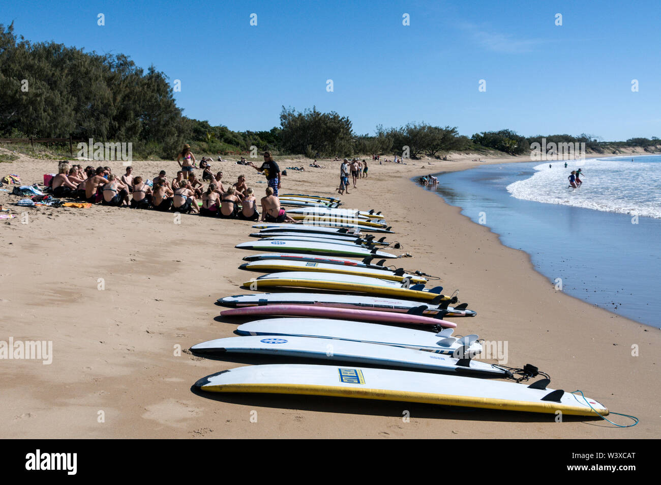 Un gruppo di giovani di wouldee surfers avente una lezione di surf su Agnes Water surf beach a Agnes Water nel Queensland, Australia Agnes Water è un sma Foto Stock