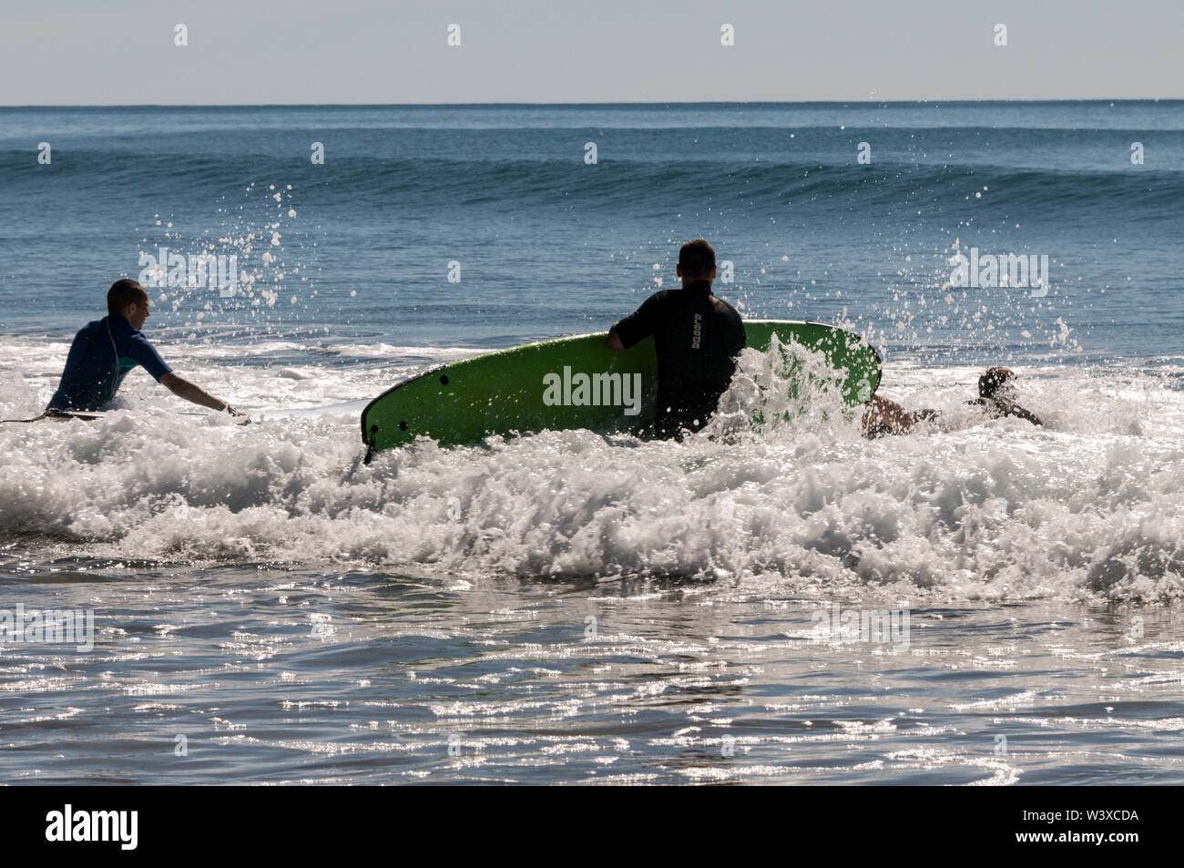Un gruppo di giovani backpackers la loro prima lezione di surf con un istruttore presso Agnes Water Beach caravan e campeggio nel Queensland, in Australia. Foto Stock