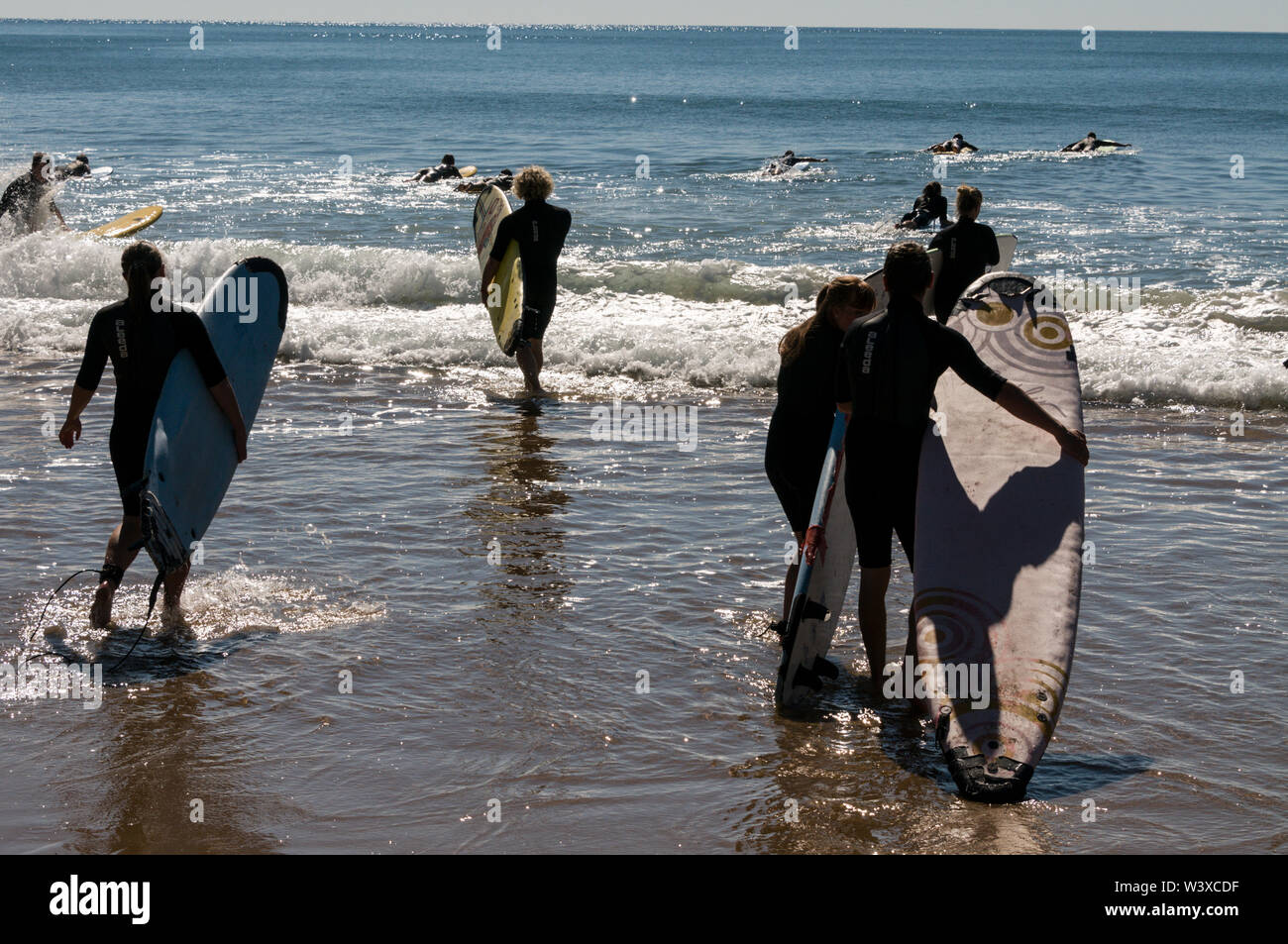 Un gruppo di giovani backpackers la loro prima lezione di surf con un istruttore presso Agnes Water Beach caravan e campeggio nel Queensland, in Australia. Foto Stock