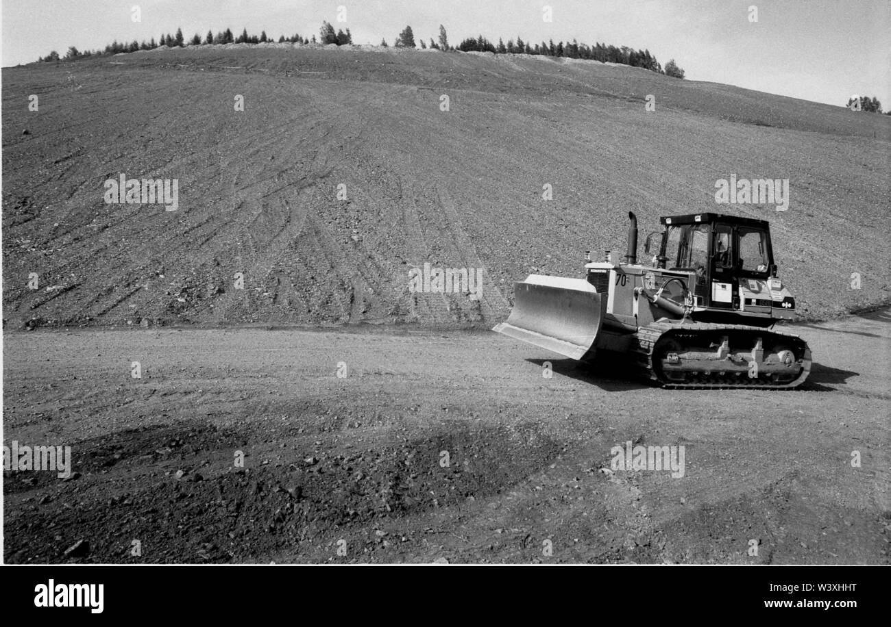 Archiviato - 01 gennaio 1992, Berlino, Aue: Sassonia/RDT/energia/1992 discariche di uranio in Schlema vicino a Aue, la bonifica dei grandi danni ambientali ha iniziato a. Il cumulo è appiattita e terrazze sono stabiliti, boccole sono piantati. Accesso per la popolazione non sarà possibile per un periodo di tempo molto lungo. I lavori di ristrutturazione saranno effettuati da WISMUT AG. Un escavatore distribuisce una miscela di terriccio e frassino // Erzgebirge/ambiente/Atom/uranio/Mining Il German-Soviet joint stock company è stata fondata dopo la nascita della Repubblica democratica tedesca per consentire l'Unione Sovietica ulteriore accesso di uranio nel Erzgeb Foto Stock