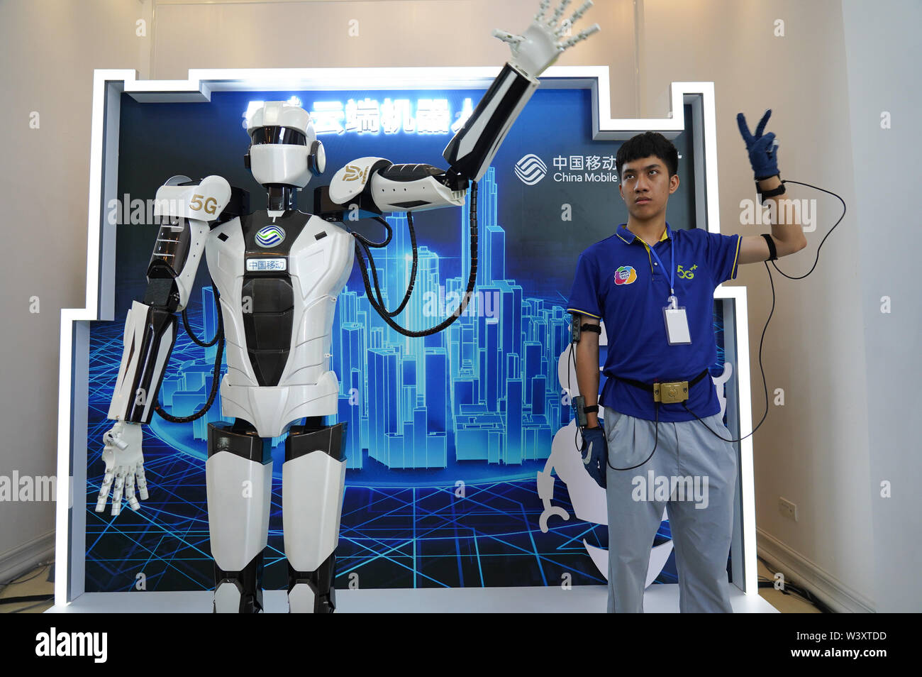 Pechino, Cina della provincia di Jiangxi. 18 Luglio, 2019. Un membro del personale controlla un robot con 5G technology durante una international mobile Internet delle cose (IOT) expo in Yingtan, Cina orientale della provincia di Jiangxi, luglio 18, 2019. Credito: Zhou Mi/Xinhua/Alamy Live News Foto Stock