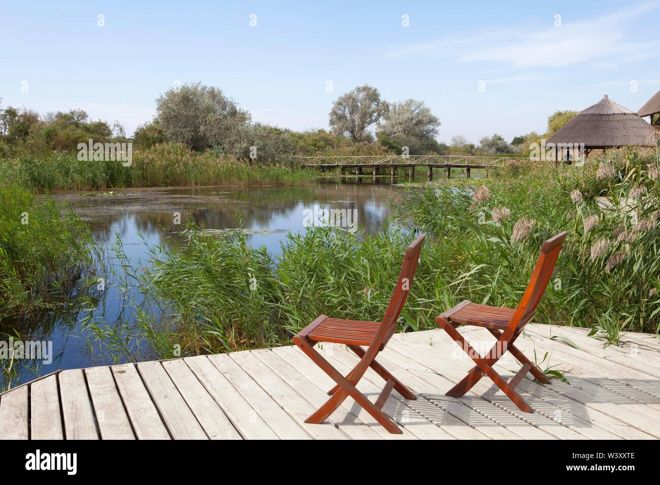 Due sedie sulla piattaforma di osservazione presso la laguna, braccio del Danubio Sfantu-Gheorghe, il Delta del Danubio Riserva della Biosfera, Dobrudscha, Romania Foto Stock