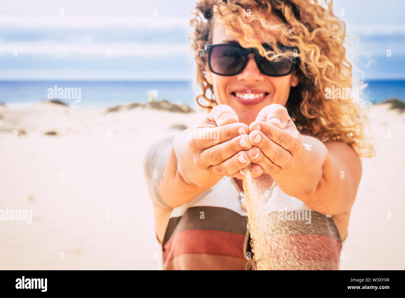 Concetto di gente viaggi e vacanze estate vacanza al resort con spiaggia perfetta - allegro felice donna bella sabbia lascia cadere dalle sue mani Foto Stock