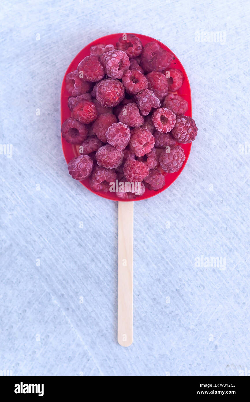 Congelate lamponi dolce con un bastone. Estate cibo. Dolce freddo dessert Foto Stock