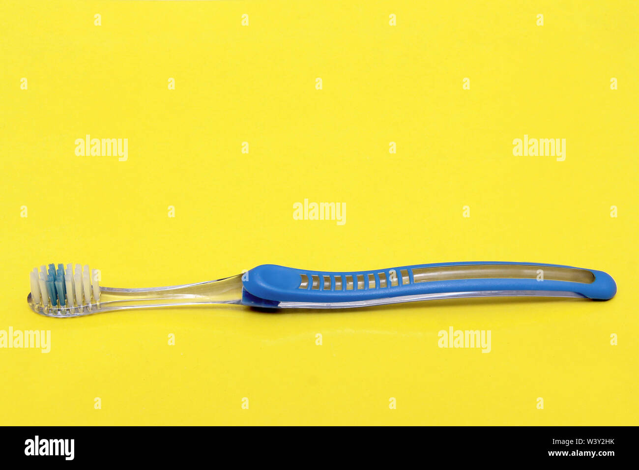 Spazzolino da denti blu su sfondo giallo. Foto Stock