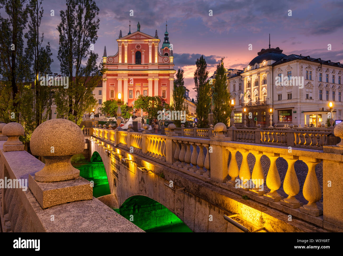 La Rosa chiesa francescana e ponte triplo Tromostovje di notte Ljubljana Slovenia EU Europe Foto Stock