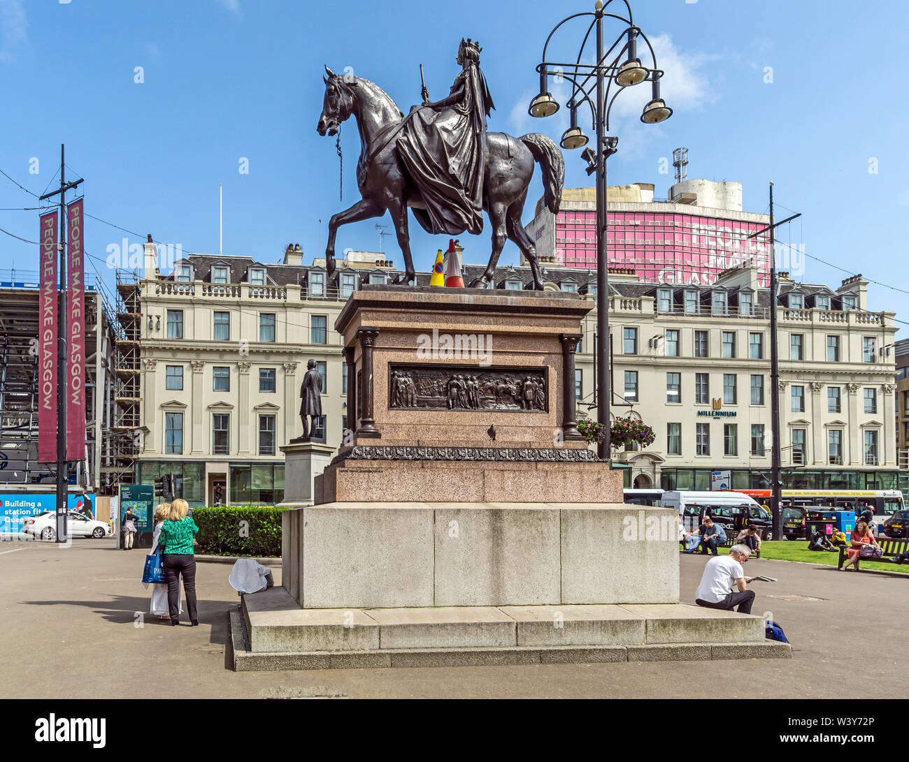 Statua della regina Victoria in George Square e centro della città di Glasgow Scotland Regno Unito con il Millennium Hotel dietro Foto Stock
