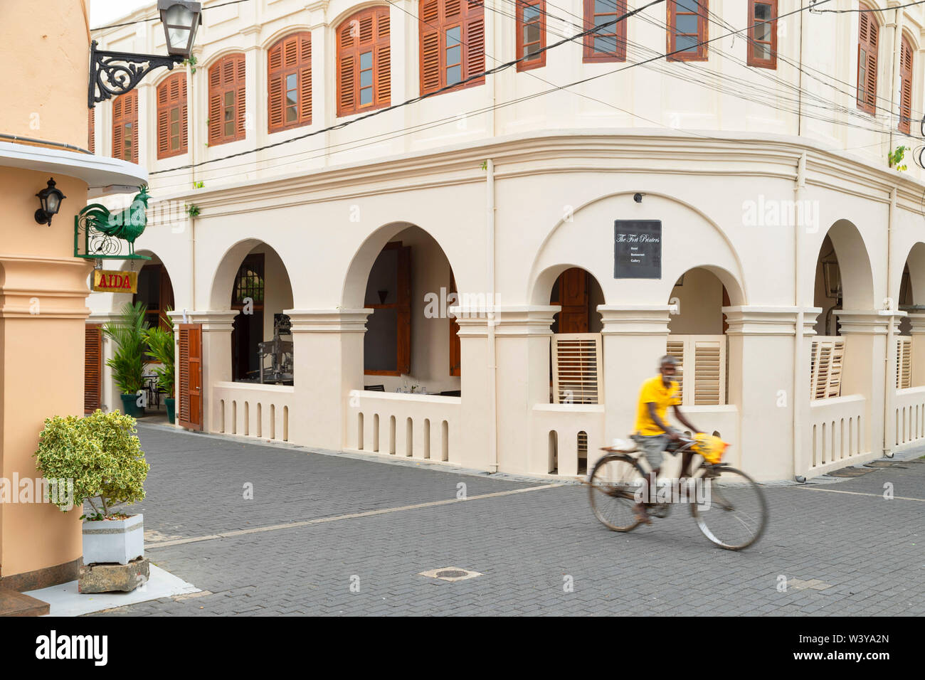 Uomo passato in bicicletta il Fort Hotel stampanti, Galle, sud della provincia, Sri Lanka Foto Stock