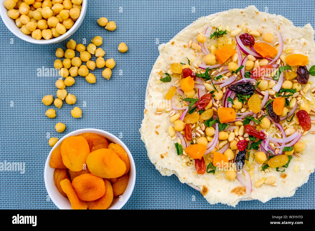 Una sana base di pizza con frutta e noci, albicocche, uva sultanina, uva passa, pinoli, cipolla rossa e ceci Foto Stock