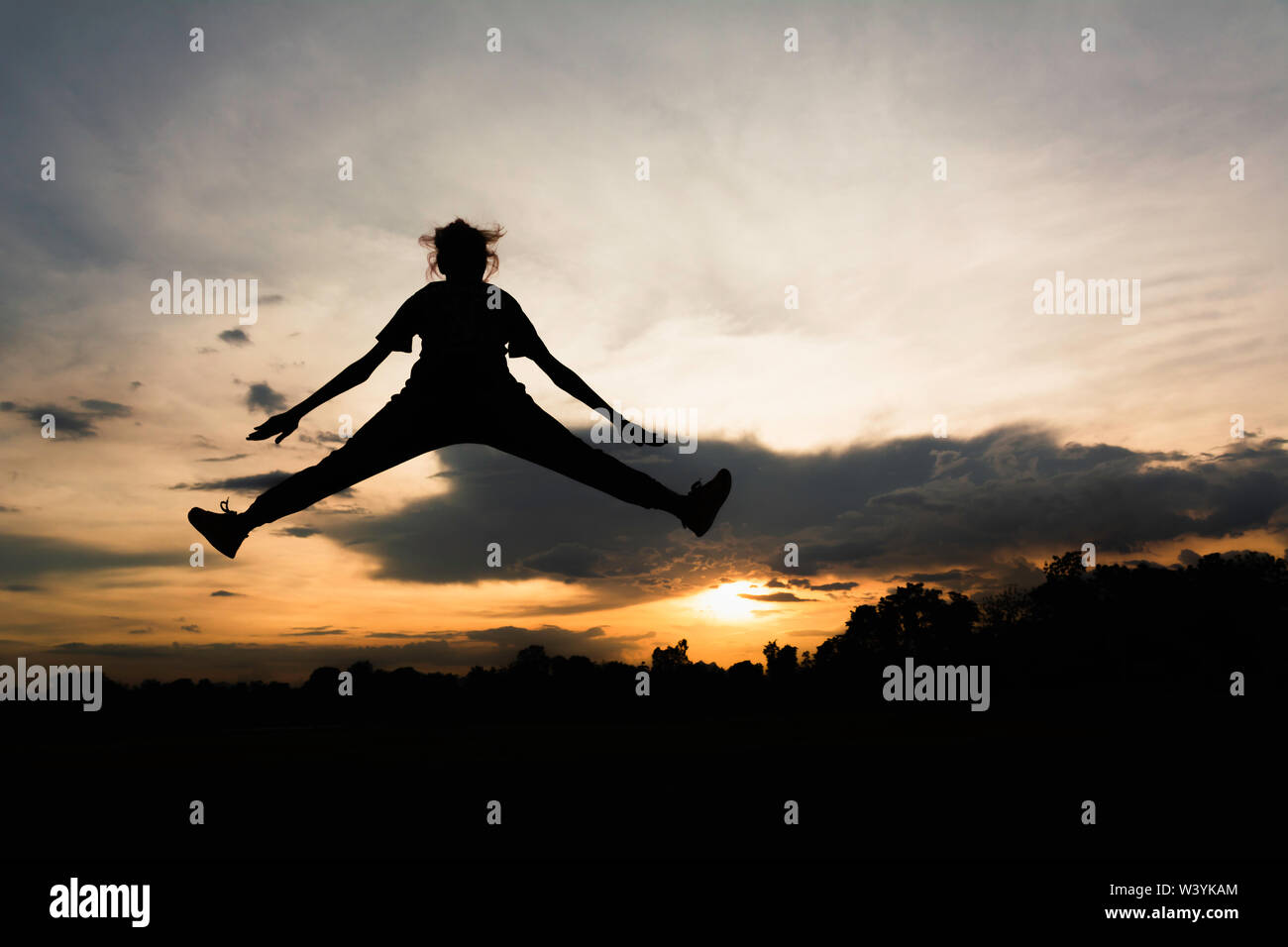 Silhouette di allegro positivo e pieno di energie ragazza di saltare in aria per la vita il concetto di energia. Foto Stock