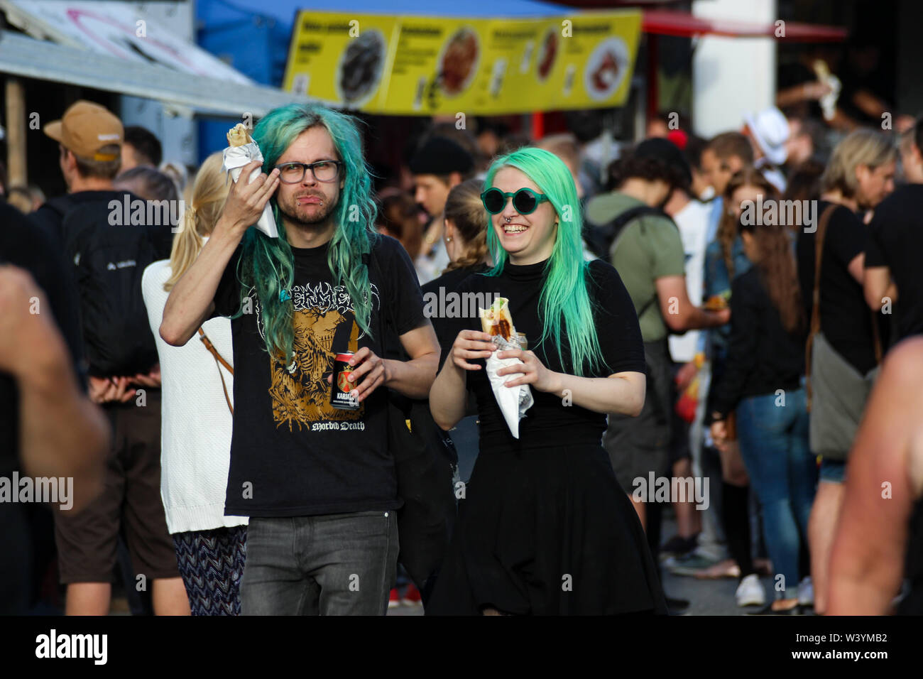 Coppia giovane con i capelli verdi strada mangiando cibo a Kallio Block Party 2016 a Helsinki in Finlandia Foto Stock