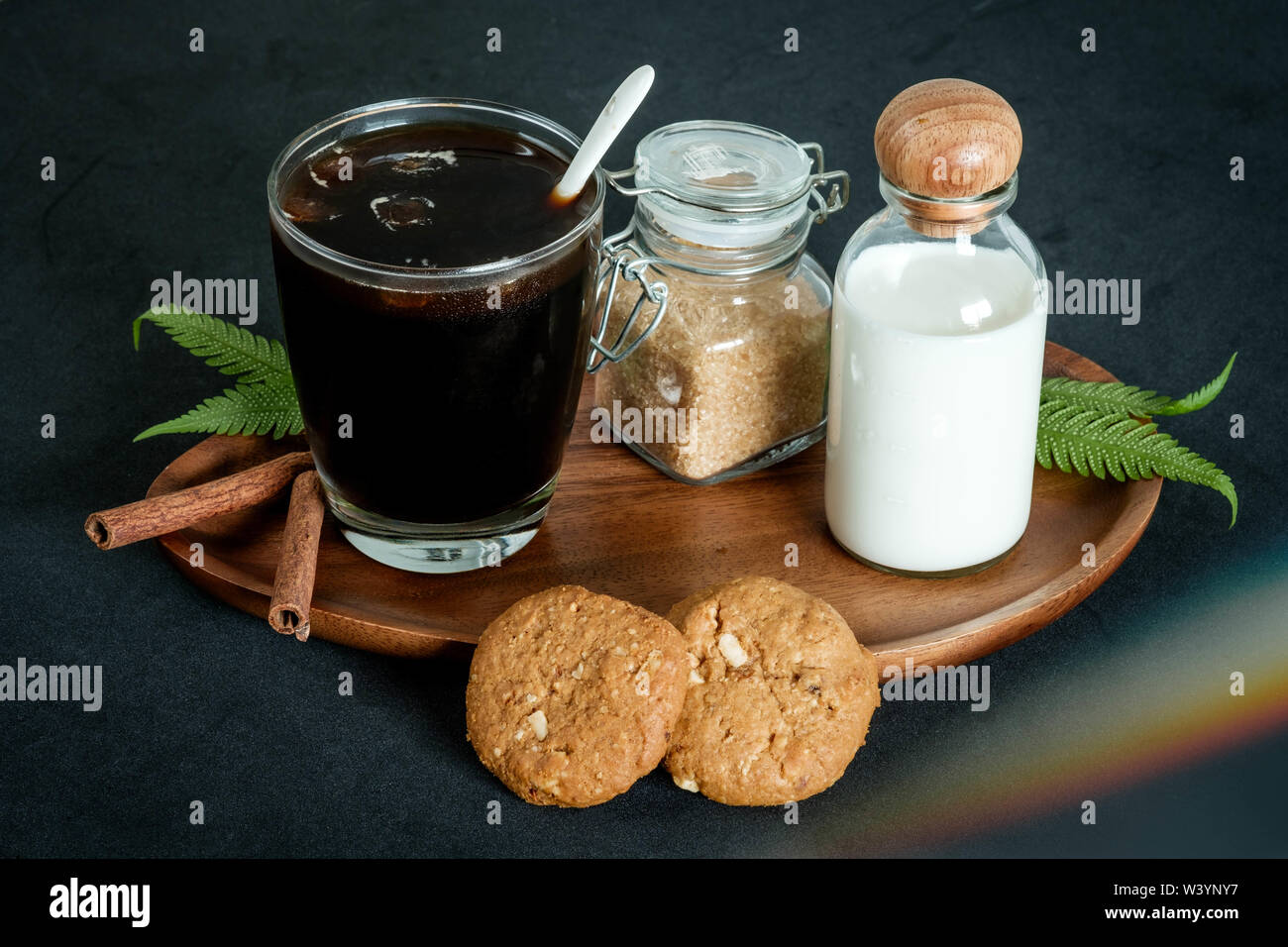 Bicchiere di caffè con zucchero di canna e i cookie di latte e cannella Foto Stock