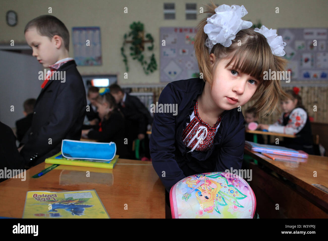 Un elementare ucraino schoolgirl in aula prepara la sua roba per la lezione durante la pausa. Radinka, Oblast di Kiev, Ucraina settentrionale Foto Stock