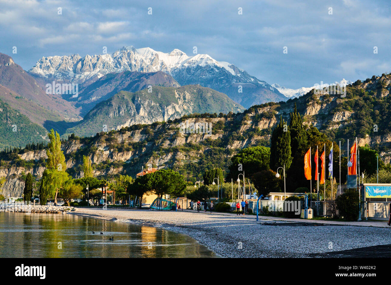 Montagne innevate visto da nord sulla spiaggia di sunrise al Lago di Garda, il Lago di Garda in Torbole - Nago, Riva, Trentino , Italia al 15 aprile 2019. © Peter Sch Foto Stock