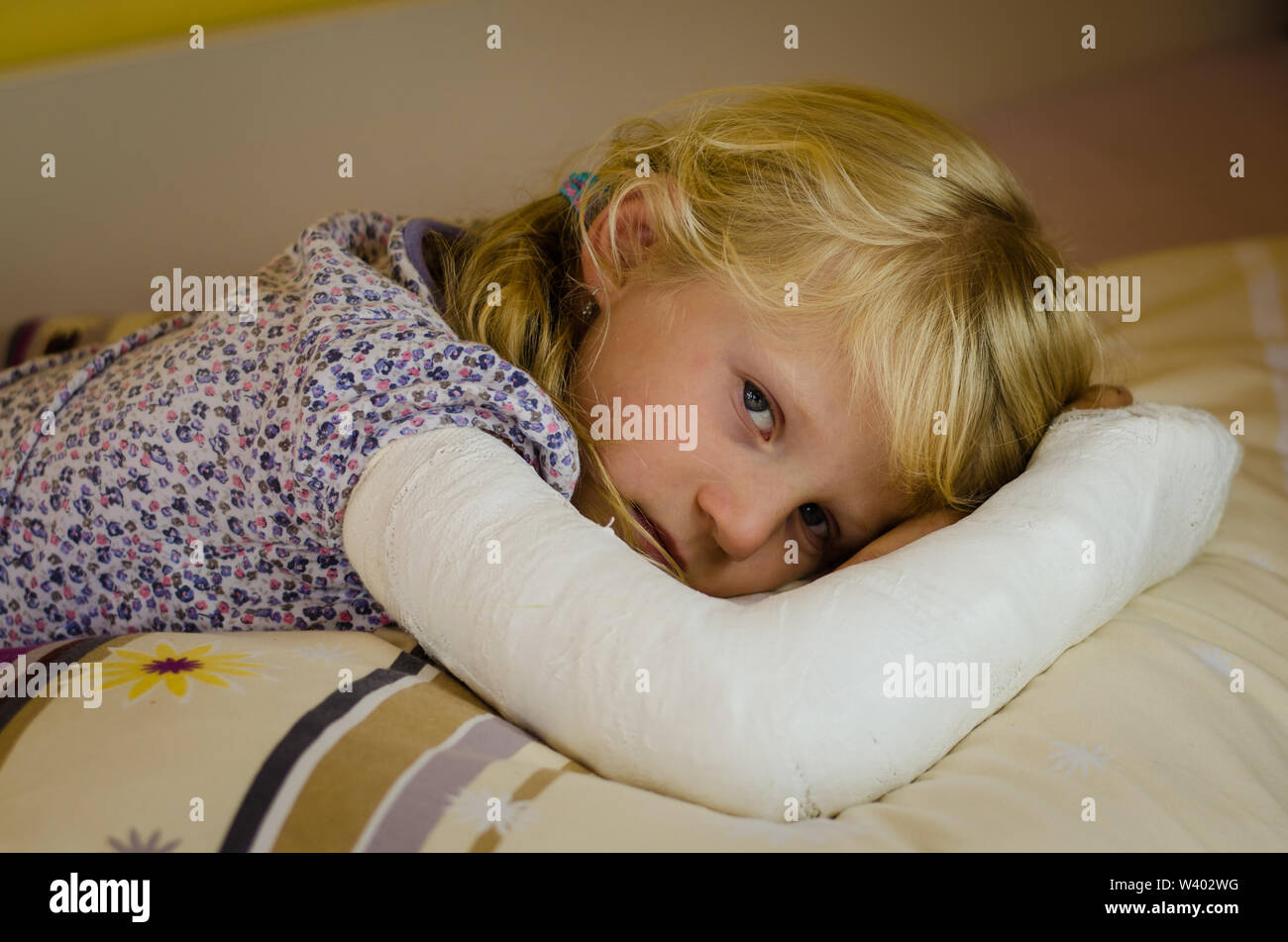 Hurt ragazza bionda con rotte giacente a mano nella mano Foto Stock