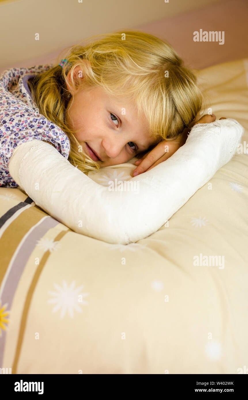 Hurt ragazza bionda con rotte giacente a mano nella mano Foto Stock