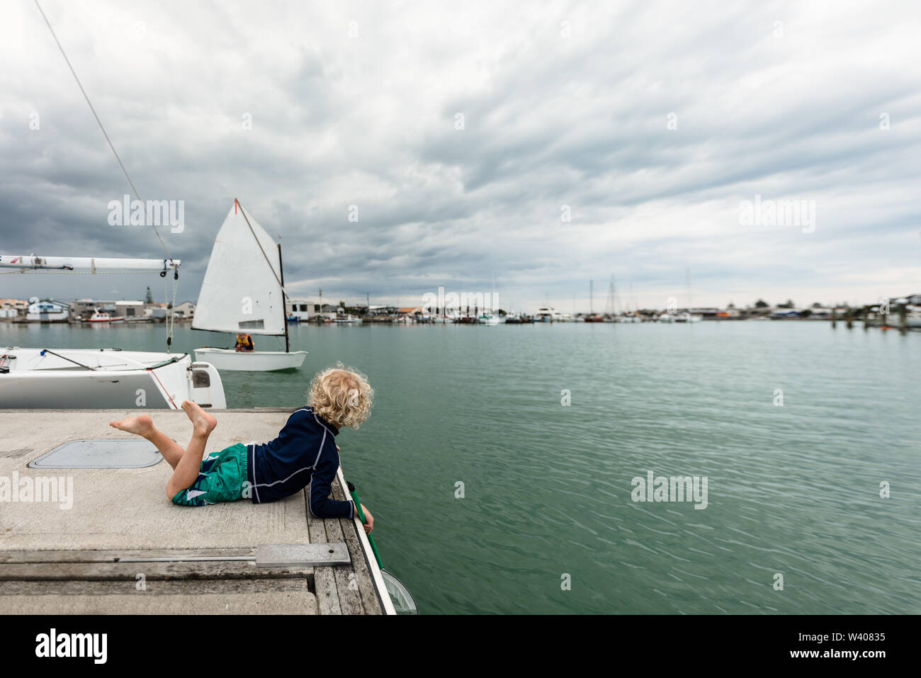 Un giovane bambino la visione di una barca a vela in Napier, Nuova Zelanda Foto Stock