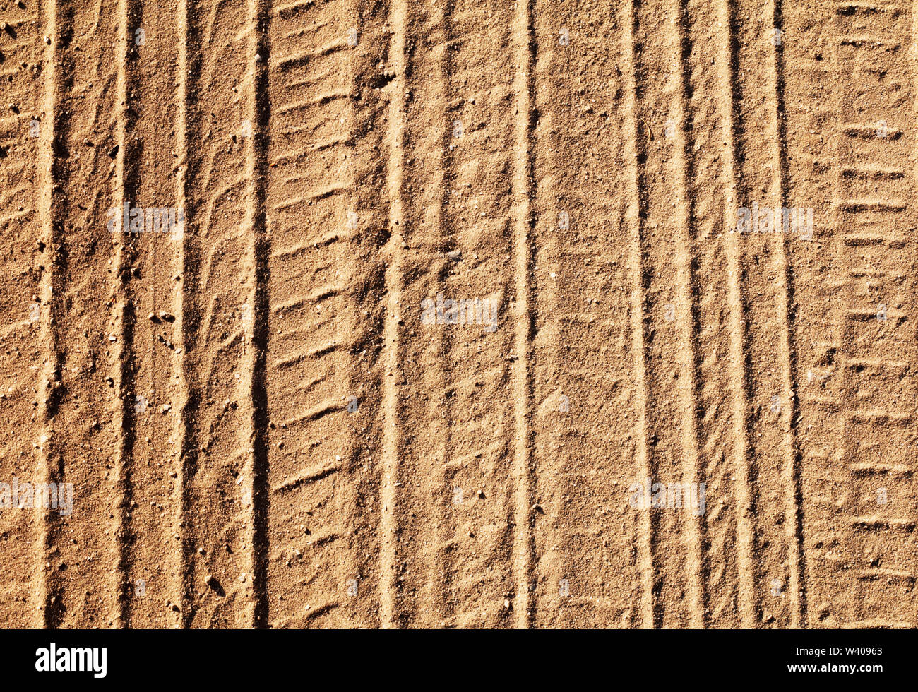 Sfondo con tracce di pneumatici su una strada di sabbia nella giornata di sole Foto Stock