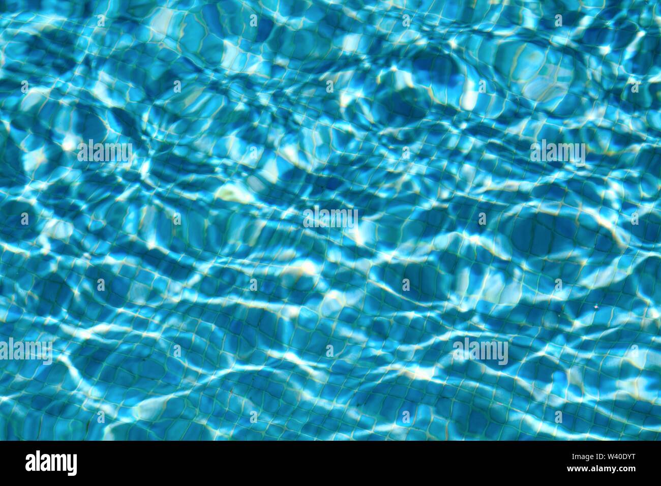 Modelli astratti formata da una forte luce solare sulla superficie di acqua in una piscina simile a David Hockney famosi dipinti Foto Stock