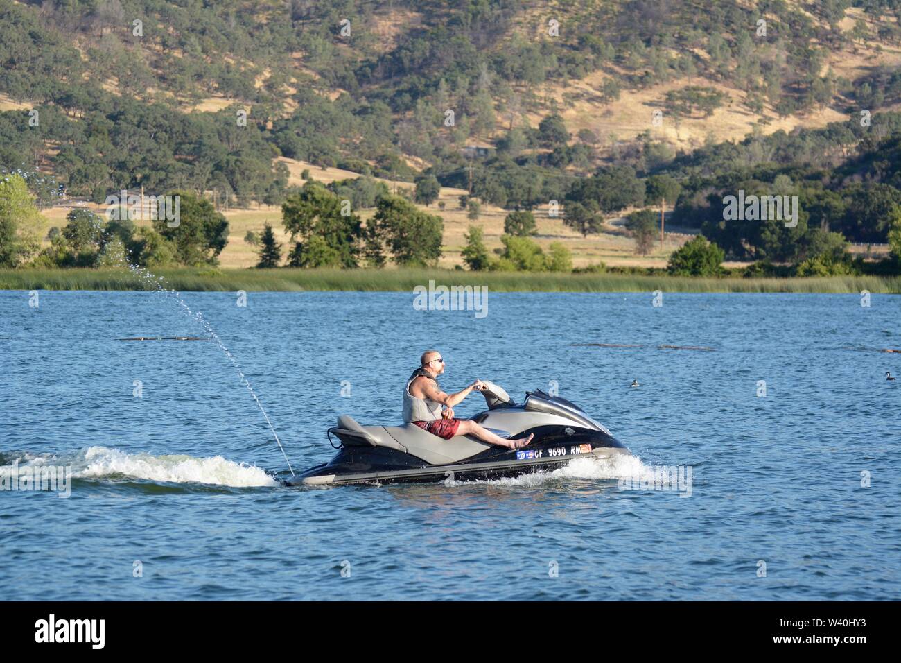 Persone su jet skis in Clear Lake Clearlake California apprendimento e avente un tempo di divertimento in vacanza e insegnare ai ragazzi sulla soleggiata giornata calda USA America Foto Stock