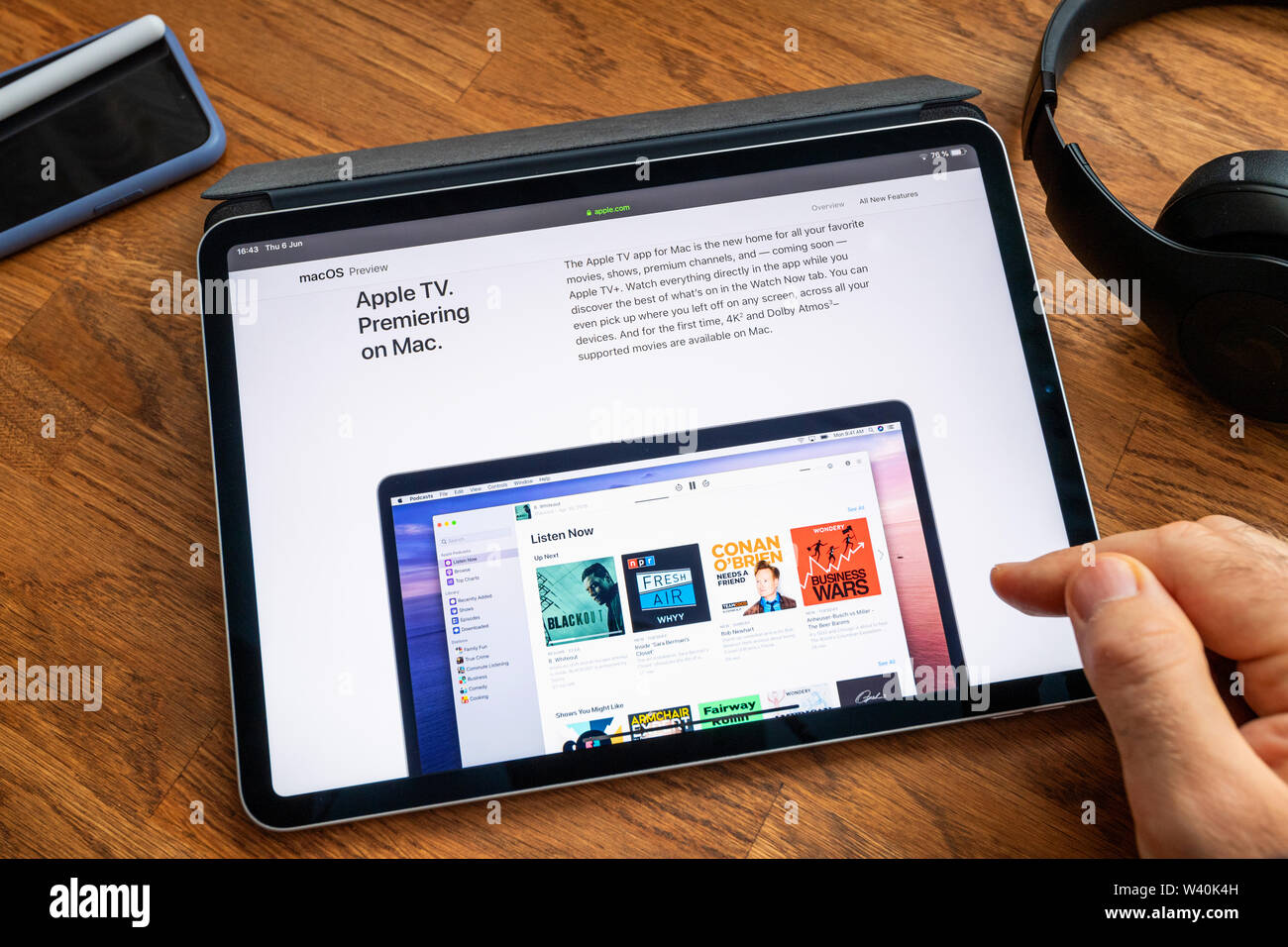 Parigi, Francia - giu 6, 2019: uomo lettura su iPad Apple Pro tablet circa il recente annuncio di alla Apple Worldwide Developers Conference WWDC - mostra la Apple TV su Mac Foto Stock