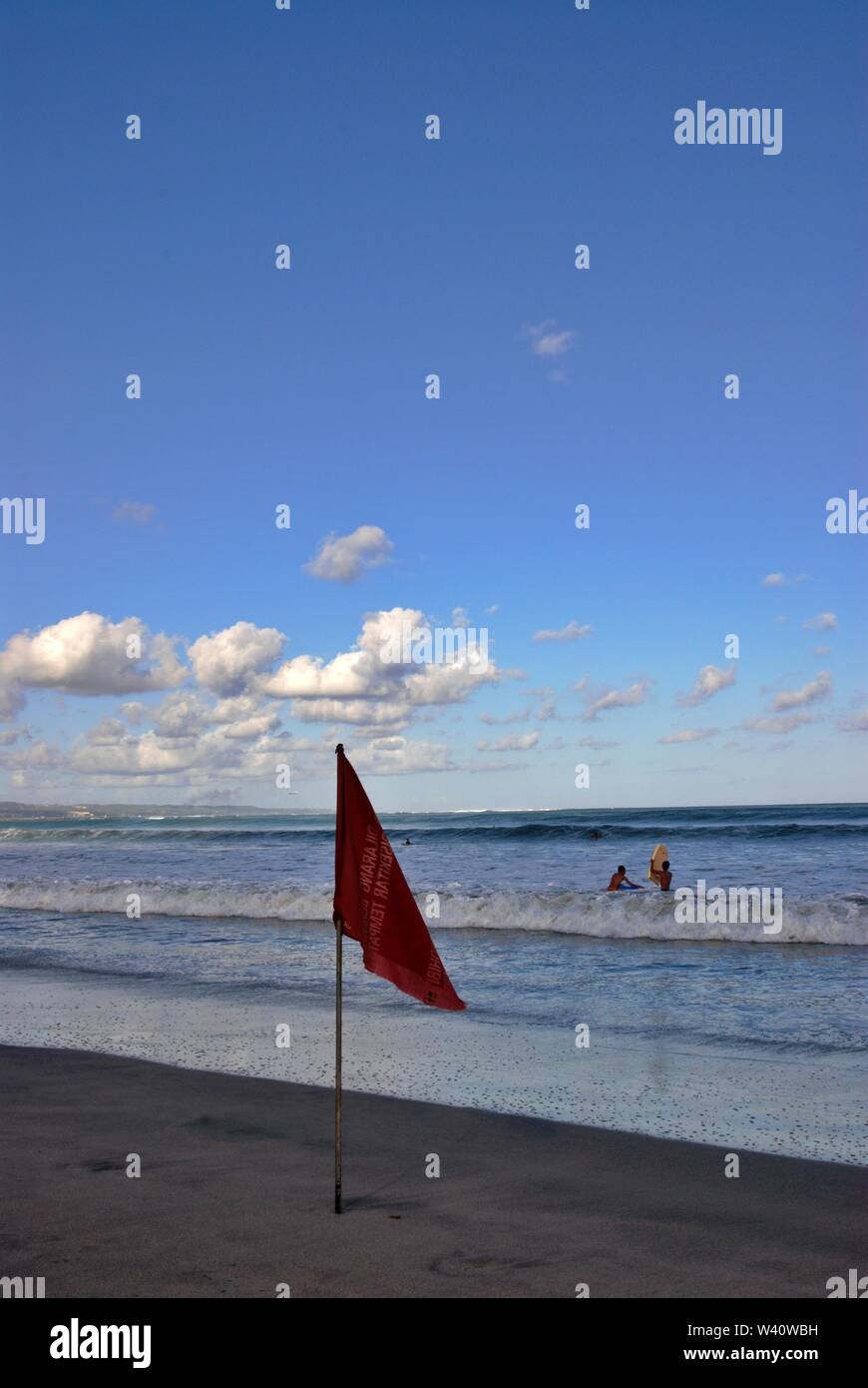 La spiaggia di Kuta Beach, Bali, Indonesia - Giugno 2019 : persone giocare su una spiaggia con un contrassegno di sicurezza. Foto Stock