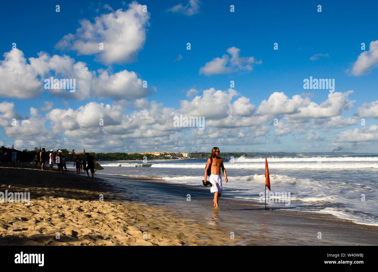 La spiaggia di Kuta Beach, Bali, Indonesia - Giugno 2019 : la gente a piedi su una spiaggia con un contrassegno di sicurezza. Foto Stock