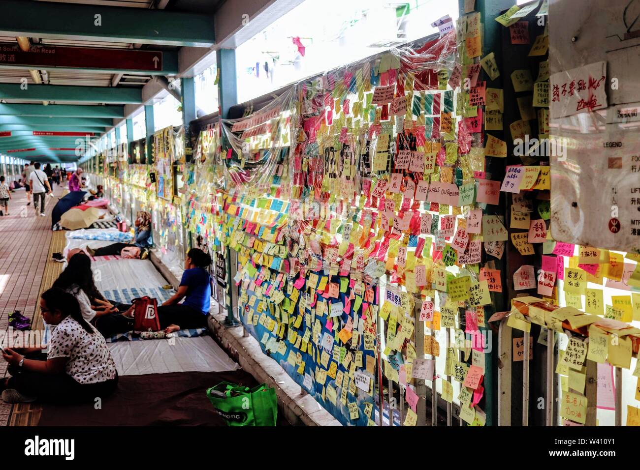 I lavoratori domestici appoggiato accanto a Lennon pareti a Mong Kok , Stazione di Hong Kong, Luglio 2019 Foto Stock