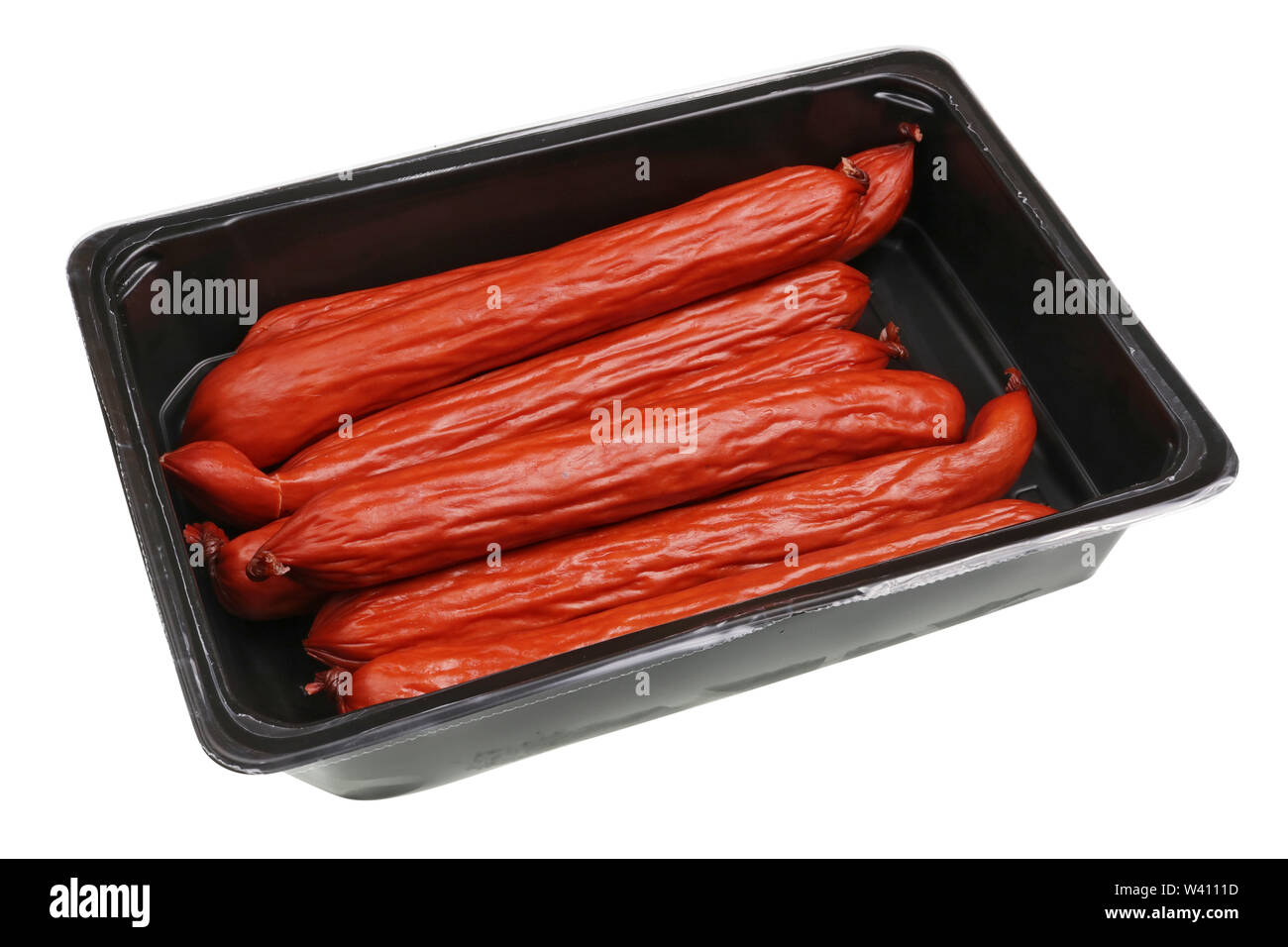 Rosso affumicati Salsicce di caccia in open black box di plastica. Isolato su bianco studio closeup Foto Stock