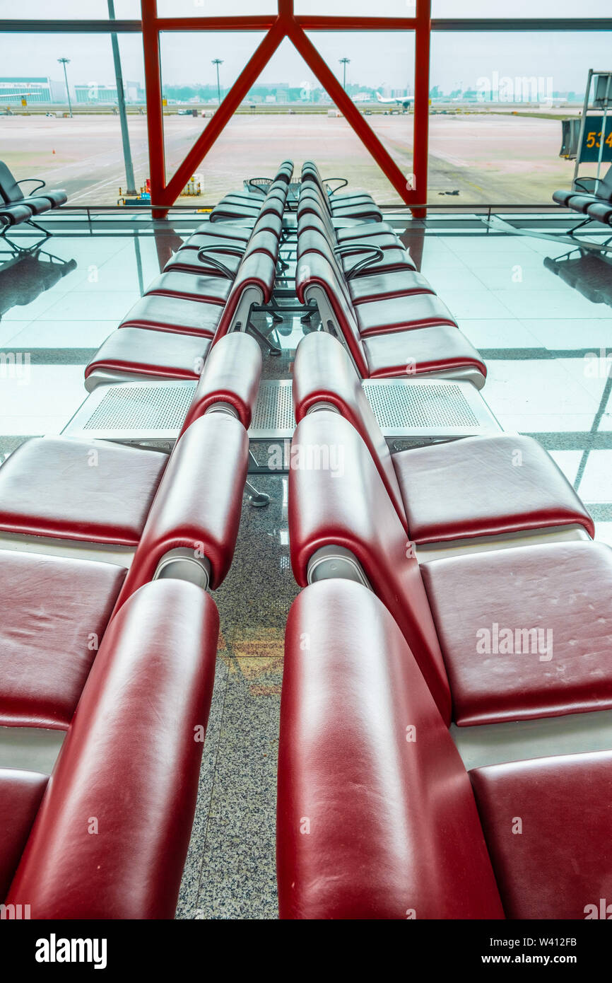 Riga di rosso posti vuoti al terminal aeroportuale - immagine verticale Foto Stock