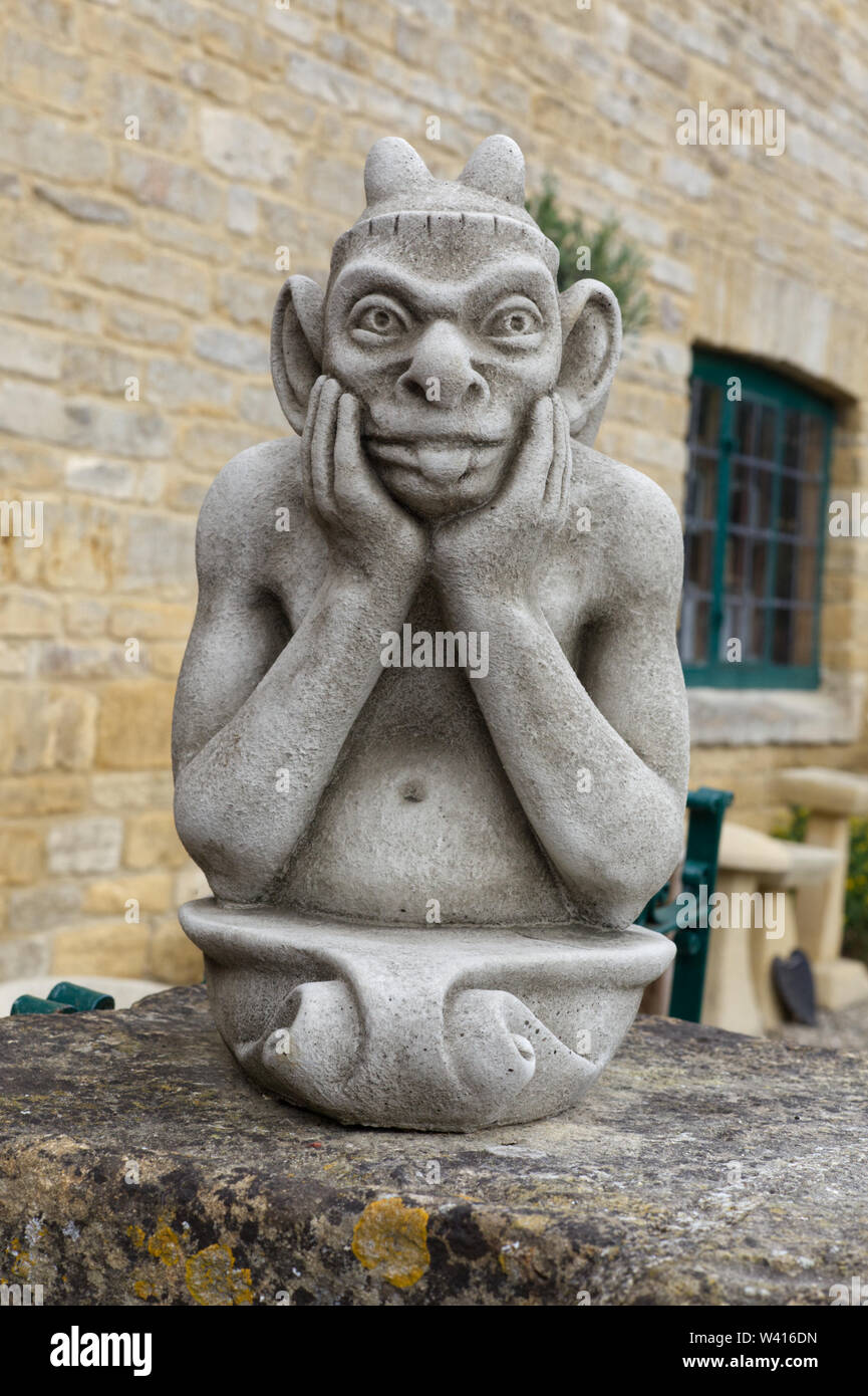 Gargoyle di pietra statua fuori la sua tong Foto Stock