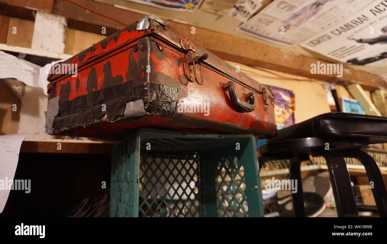 Basement Studio della metropolitana, cineasta sperimentale Craig Baldwin. La missione del Distretto di San Francisco, California. Vintage valigia rosso con nastro per condotti Foto Stock