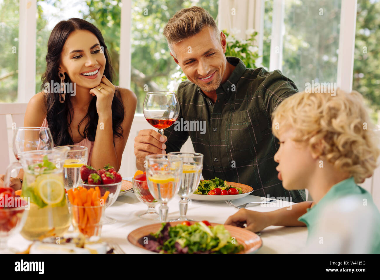 Trasmissione via IR di genitori sorridere mentre ascolto la loro simpatico smart figlio Foto Stock