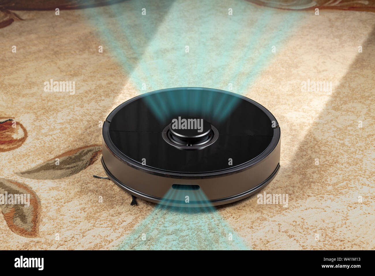 L'aspirapolvere robot nella stanza pulisce il tappeto Foto Stock