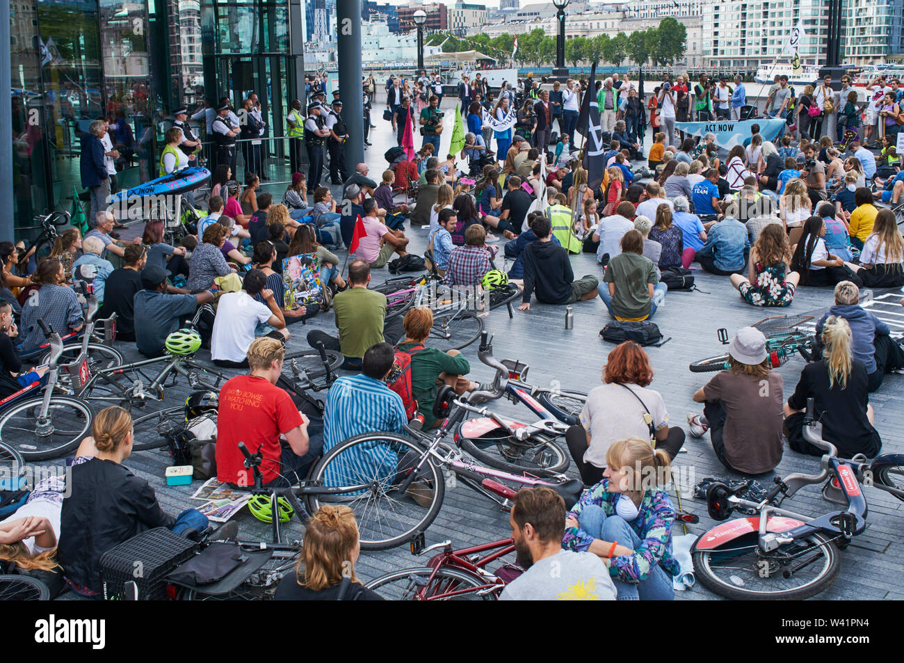 La Ribellione di estinzione il cambiamento climatico manifestanti ascolto di interventi al di fuori dell'entrata al City Hall, Londra UK, il 18 Luglio 2019 Foto Stock