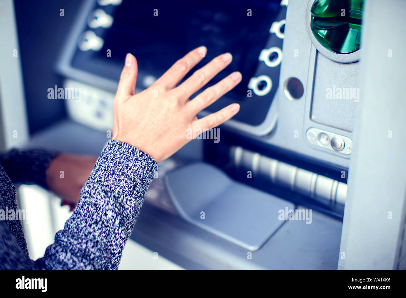 Stretta di mano femmina immettendo il PIN/pass codice su ATM/banca tastiera della macchina, essa nasconde con l'altra mano per scopi di sicurezza Foto Stock