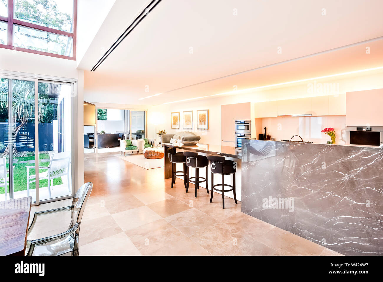 Casa indoor e outdoor compresa cucina e soggiorno, vi è un giardino esterno può essere visto attraverso la porta di vetro, il contatore di lucido e a parete Foto Stock