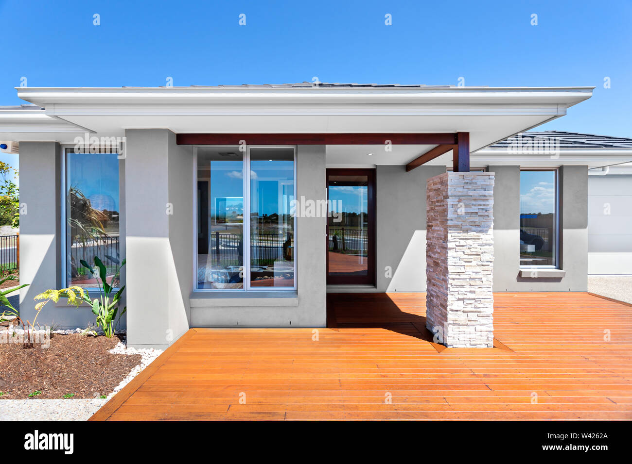 Davanti a una casa moderna con cantiere in legno. Il tetto è sostenuto da forti travi con pietre e mattoni a vista pilastro. La casa dispone di almeno quattro in Windows Vista Foto Stock