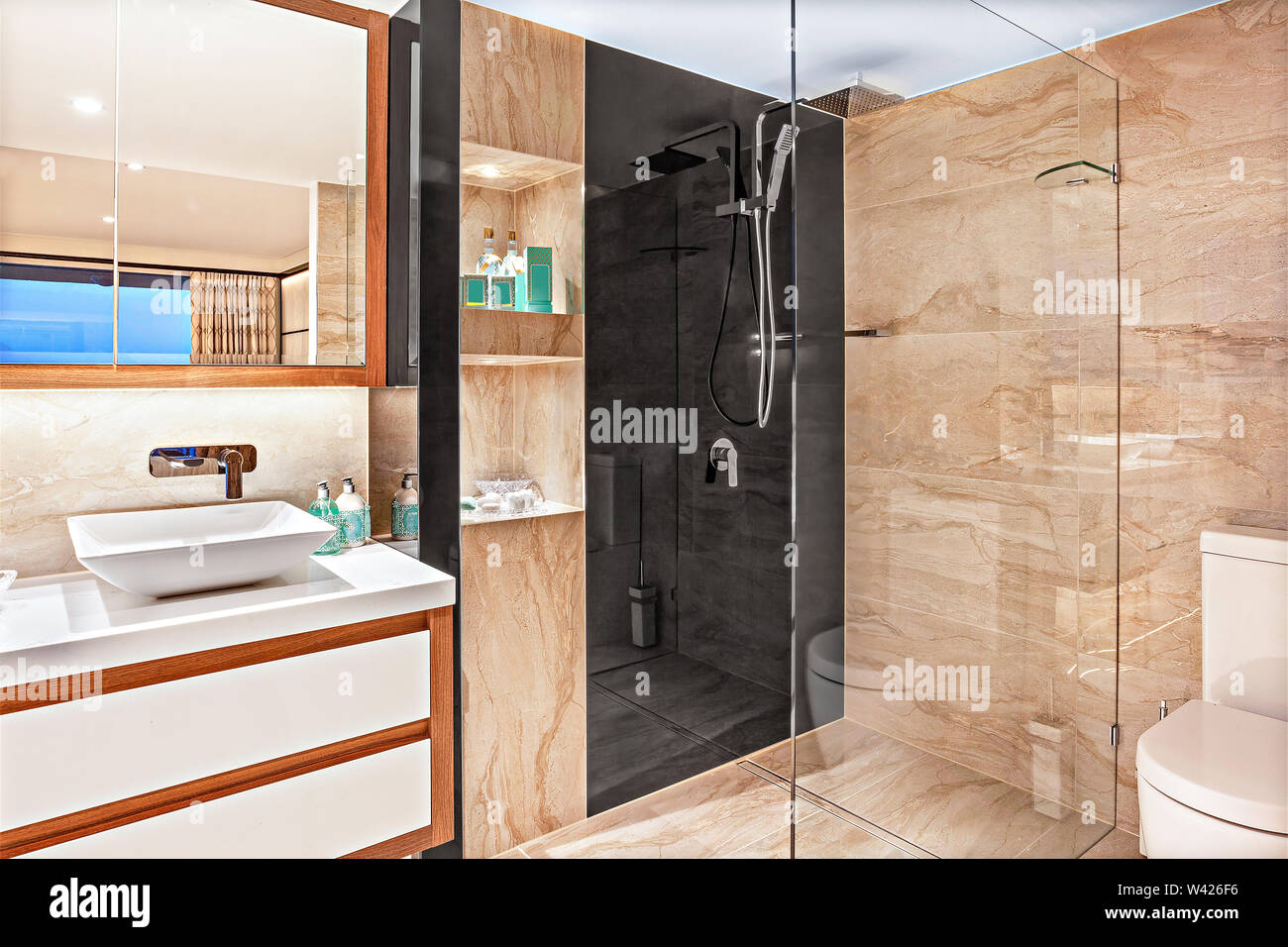 Un voguish bagno con un vetro-doccia separata area, un bacino di vanità e un sedile di gabinetto Foto Stock