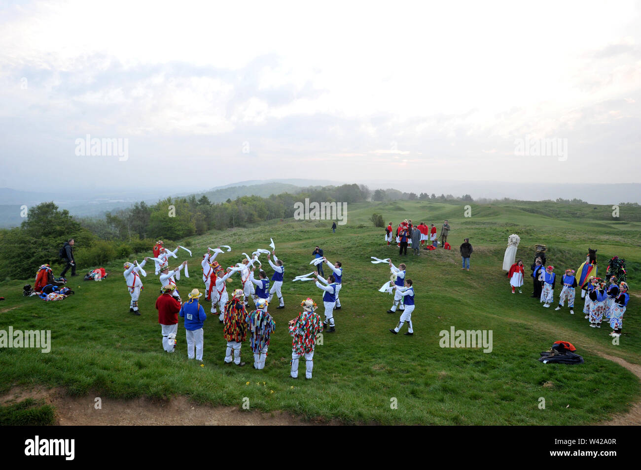 Morris Dancing n top di Painswick Beacon per celebrare sunrise il giorno di maggio Foto Stock