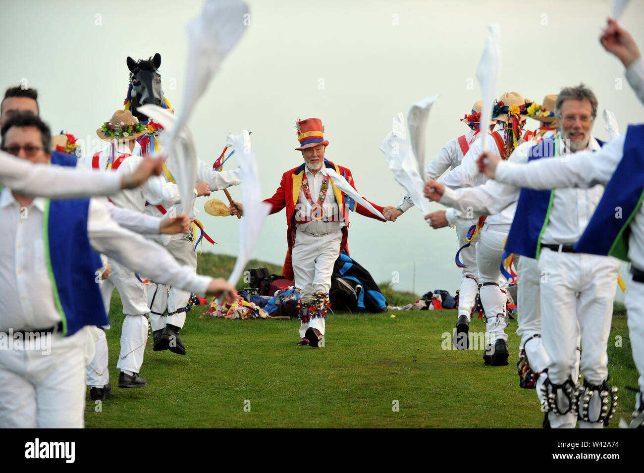 Morris Dancing sulla sommità di Painswick Beacon per celebrare sunrise il giorno di maggio Foto Stock