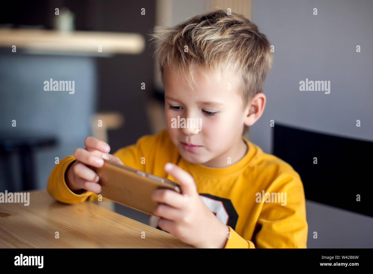 I bambini, la tecnologia e il concetto di internet. Poco sorridente ragazzo bambini giocare o navigare su internet su smartphone digitale Foto Stock