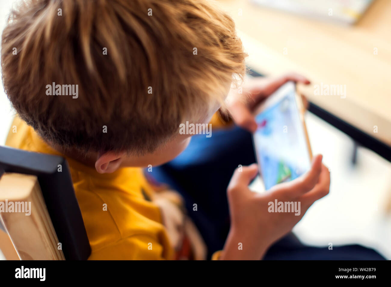 I bambini, la tecnologia e il concetto di internet. Poco sorridente ragazzo bambini giocare o navigare su internet su smartphone digitale Foto Stock