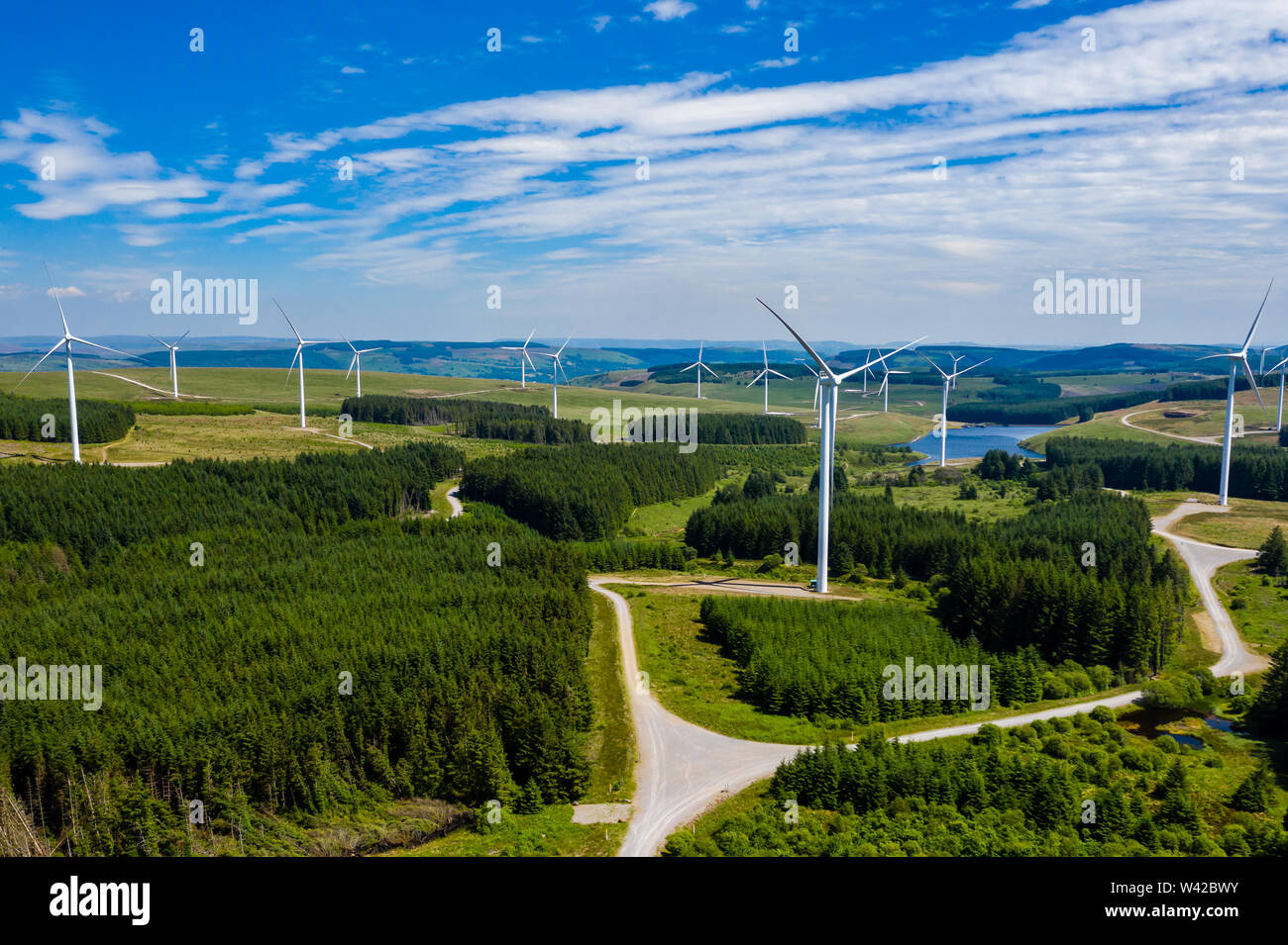 Antenna vista drone di grandi centrali eoliche onshore su una verde collina Foto Stock