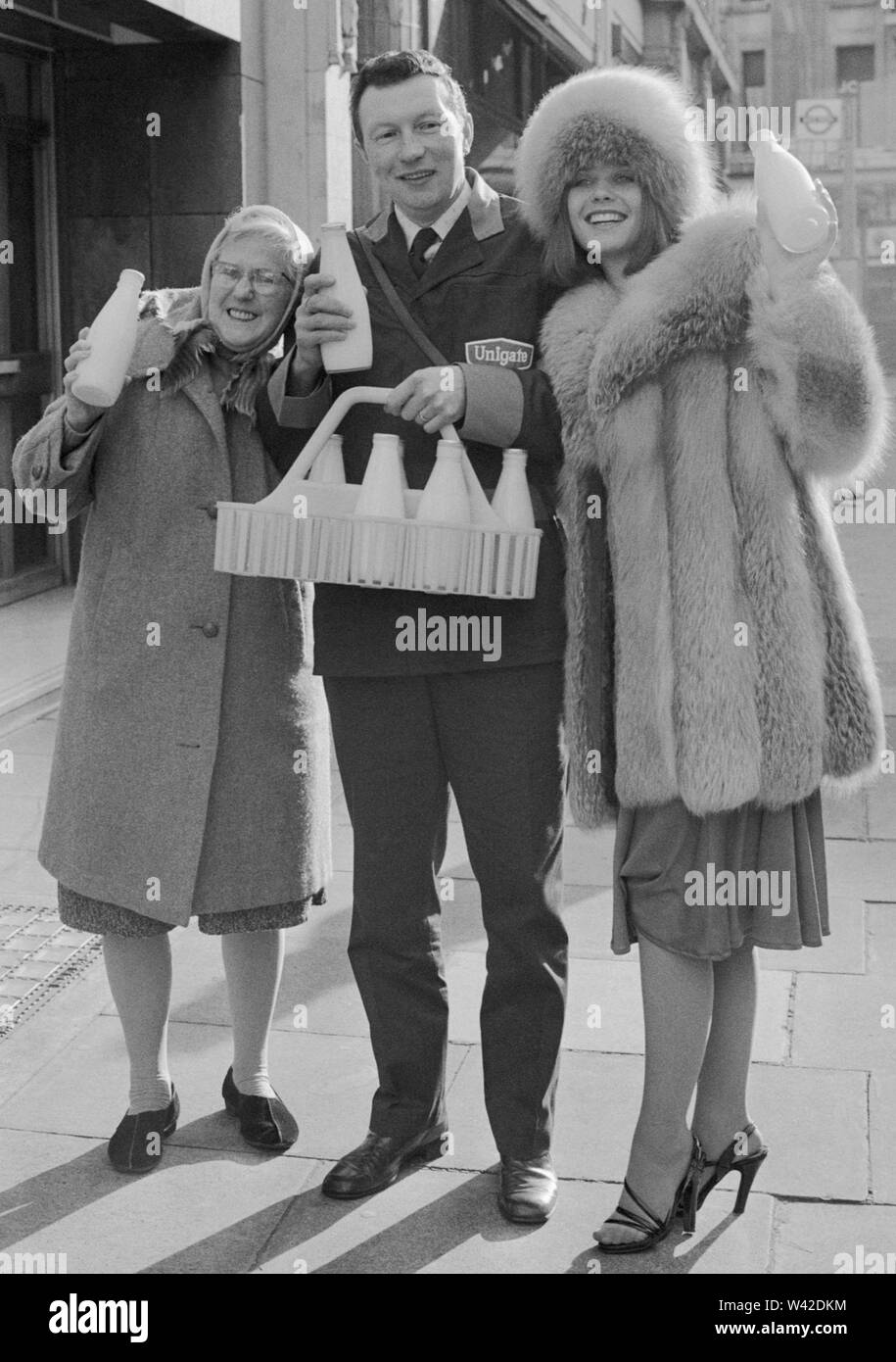 Presso la latteria nazionale Centro Peter Lucas, 43, di Dorking, chi è impiegato da Unigate Ltd a loro Westcott Depot a Dorking. Accanto a lui è Susan bracciale (r), Miss Gran Bretagna, chi lo ha presentato con il premio di £500 per la conquista del titolo di "personalità lattaio per 1976". La massaia che lo ha nominato è Francesca Westbrook (l), 72 di Dorking, che ha anche ricevuto £500 da Susan bracciale. Foto Stock