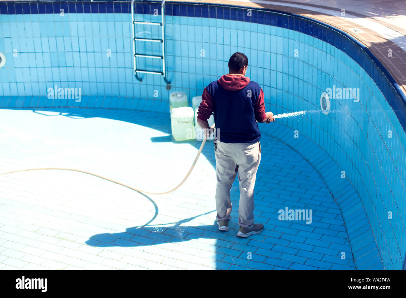 Servizi di assistenza e manutenzione della piscina. L'uomo pulisce la piscina. Foto Stock