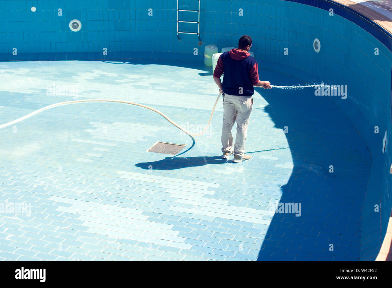 Servizi di assistenza e manutenzione della piscina. L'uomo pulisce la piscina. Foto Stock