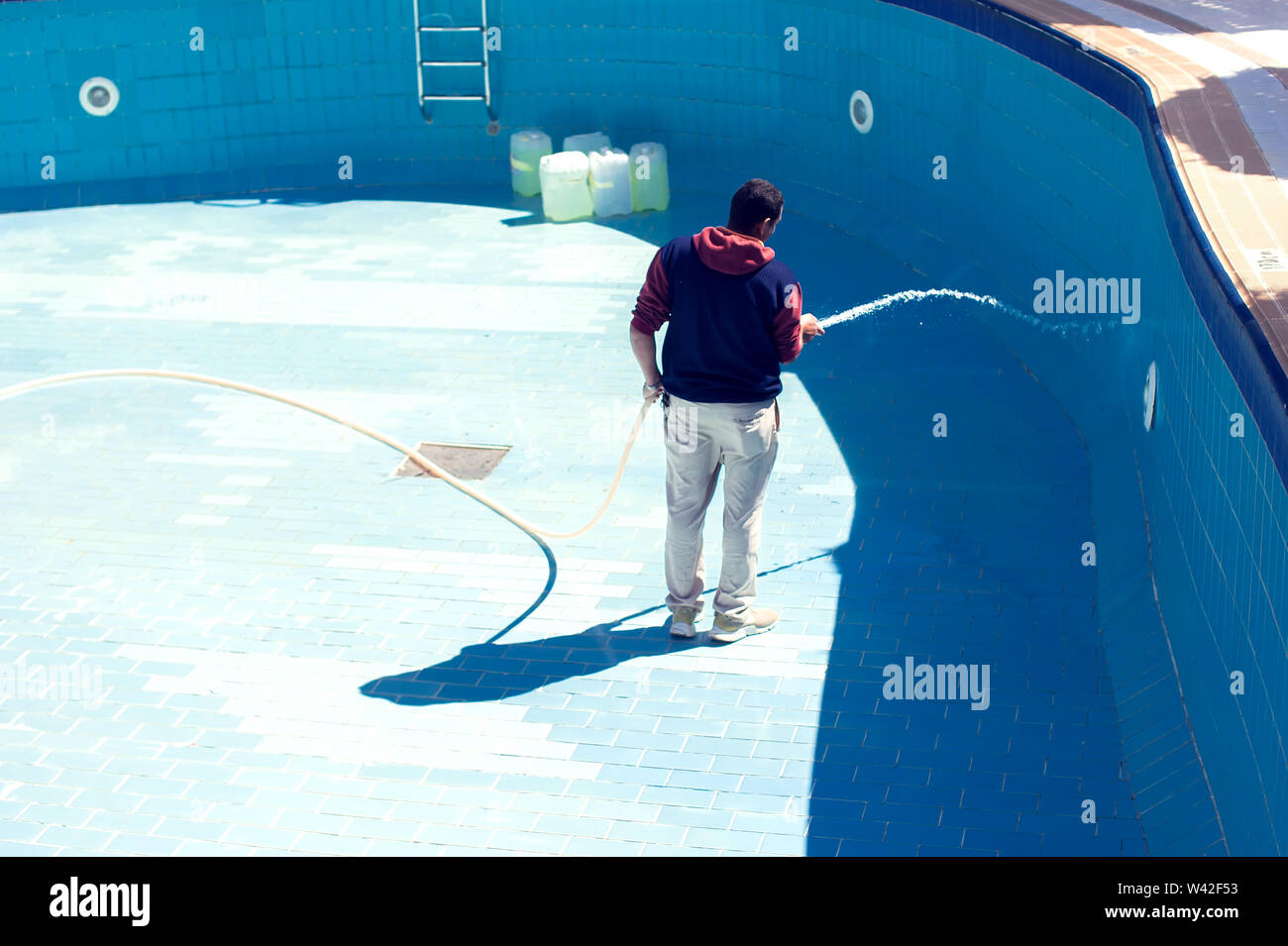 Servizi di assistenza e manutenzione della piscina. L'uomo pulisce la piscina. Foto Stock