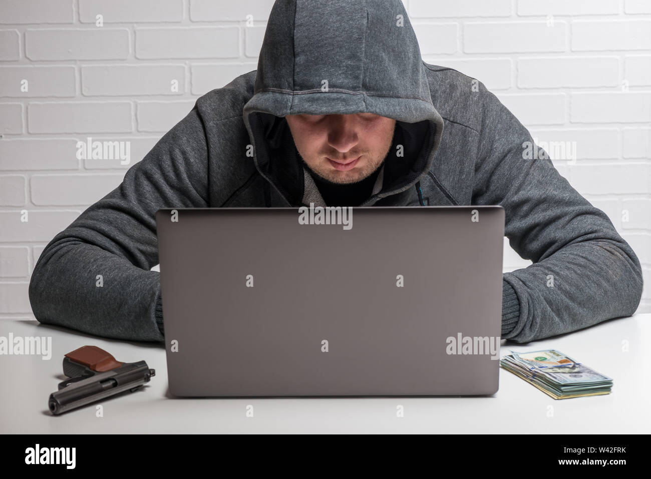 Un utente malintenzionato ruba i dati personali nel computer, il pirata informatico nel cofano al lavoro Foto Stock