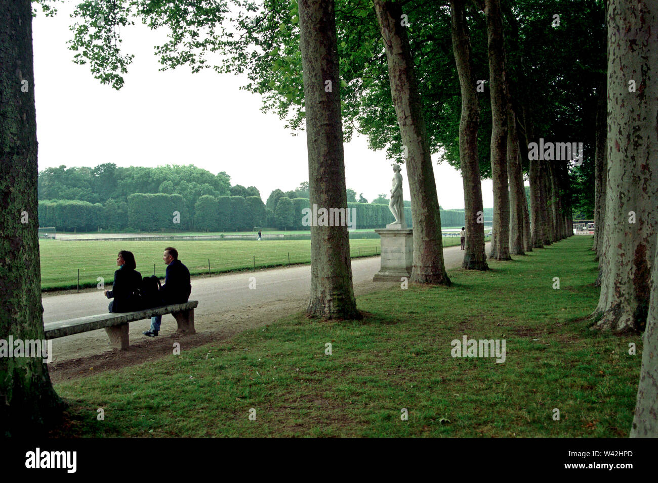 Nel giardino di Versailles, dopo aver camminato attraverso i massicci terreni di Versailles, due turisti americani si prendono uno sfiato molto necessario, Foto Stock